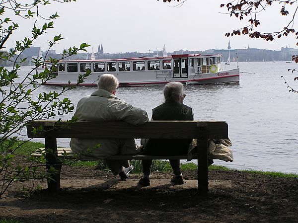 2200_118_30 Ein älteres Ehepaar sitzt auf einer Parkbank am Alsterufer. | Alsterschiffe - Fahrgastschiffe auf der Alster und den Hamburger Kanälen.